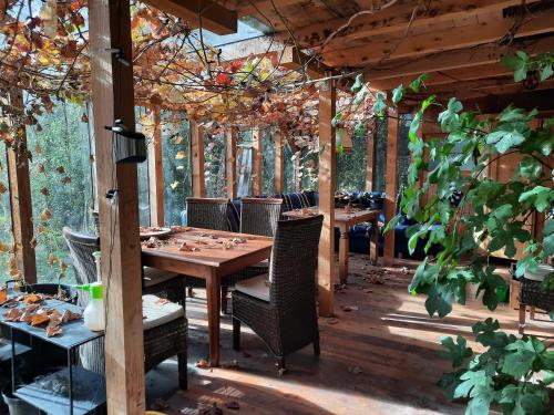 ein Esszimmer mit Tischen, Stühlen und Bäumen in der Unterkunft Bauernhaus im Permakultur-Garten in Sankt Johann in Tirol