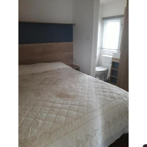 a bedroom with a large white bed with a window at The retreat in Carlisle