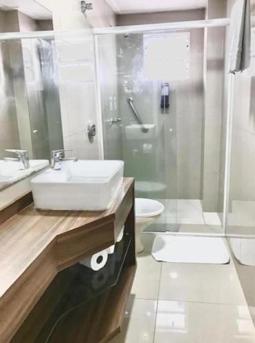 a bathroom with a sink and a shower and a toilet at Hotel Sibara SPA & Convenções in Balneário Camboriú