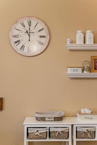 a clock on the wall above a white table at Old Town Vintage Apartment Sturova in Košice