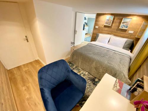 1 dormitorio con 1 cama y 1 silla azul en Appartament Bel Air en Cherbourg en Cotentin