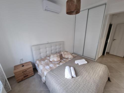 een slaapkamer met 2 bedden en handdoeken bij AGORA luxury APARTMENT 1 in Loutraki