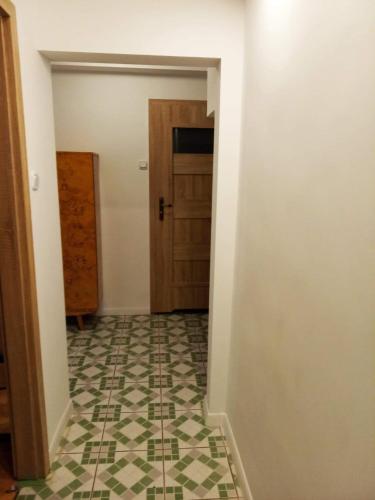 a hallway with a door and a tiled floor at Apartament Doris in Ciechocinek