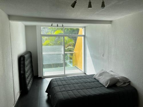 a bedroom with a bed in front of a window at Casa Lían in Cuernavaca