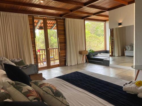 um quarto com uma cama grande e uma sala de estar em Pousada Vereda da Serra em Pirenópolis