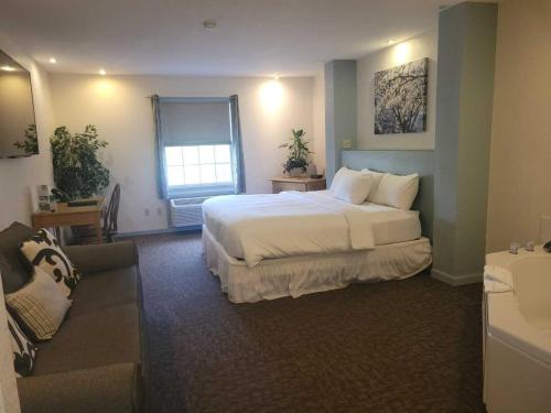 a hotel room with a bed and a couch at Brook Pointe Resort in Syracuse
