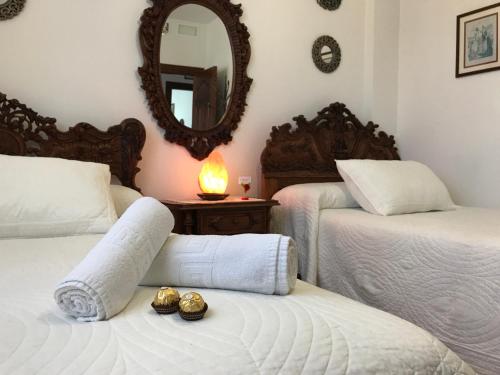 1 dormitorio con 2 camas y espejo en Casa Pedro en Roquetas de Mar