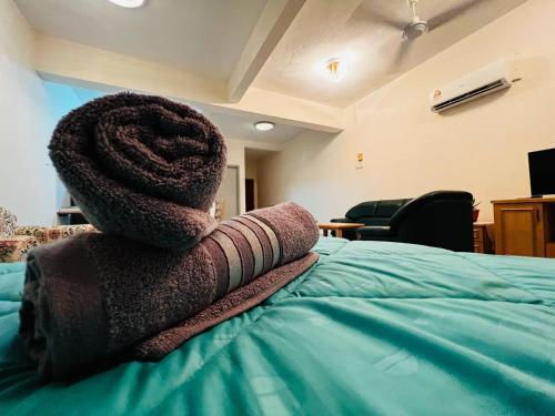 uma pilha de toalhas sentadas em cima de uma cama em Hijauan Studio Unit @ Ocean View Resort em Porto Dickson