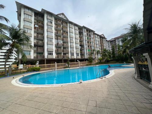 uma piscina em frente a um grande edifício de apartamentos em Hijauan Studio Unit @ Ocean View Resort em Porto Dickson