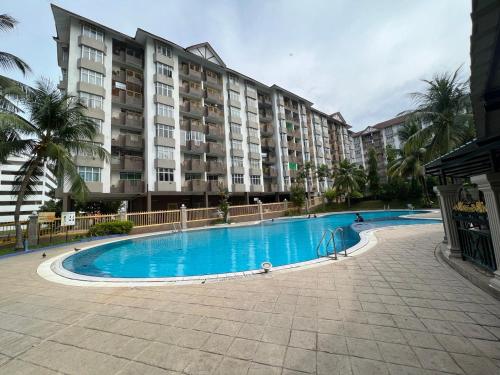 a swimming pool in front of a large apartment building at Hijauan Studio Unit @ Ocean View Resort in Port Dickson