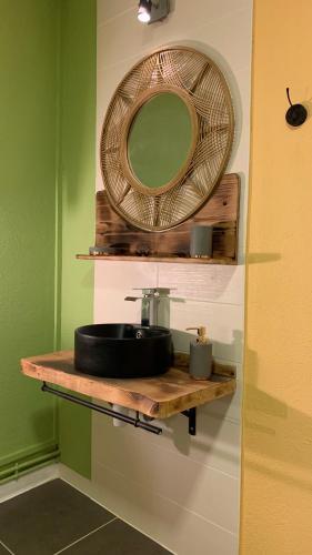 La salle de bains est pourvue d'un lavabo et d'un miroir sur une étagère. dans l'établissement La casa, à Uchizy