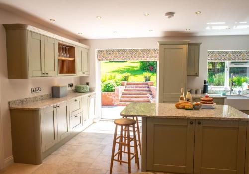 a kitchen with white cabinets and a large island at Country Crabtree Bungalow with large wild garden 