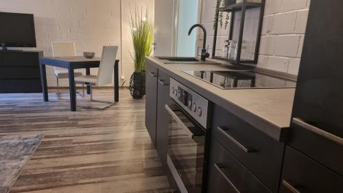 a kitchen with a sink and a stove and a table at FP-Immobilien in Harsum