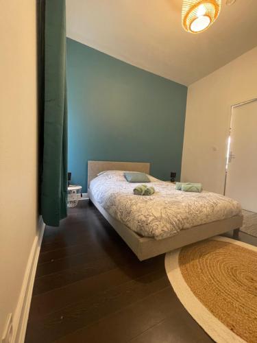 une chambre avec un lit et un mur bleu dans l'établissement Le charmant de Rompsay, Familial & Moderne, à La Rochelle