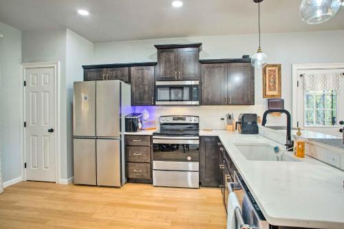 a kitchen with wooden cabinets and stainless steel appliances at Denison Home with Balcony Walk to Downtown! in Denison
