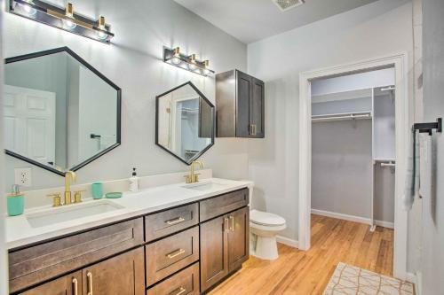 a bathroom with a sink and a toilet and a mirror at Denison Home with Balcony Walk to Downtown! in Denison