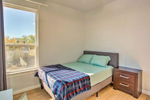 a small bedroom with a bed and a window at Denison Home with Balcony Walk to Downtown! in Denison