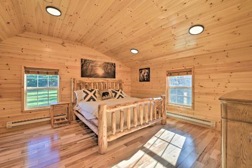 Unadilla Cabin on 50 Acres and Fire Pit and Creek في Unadilla: كابينة خشب غرفة نوم بها سرير ونوافذ