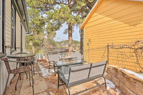 a patio with a table and chairs and a bench at Mountain-View Lead Home with Patio and Fire Pit! in Lead