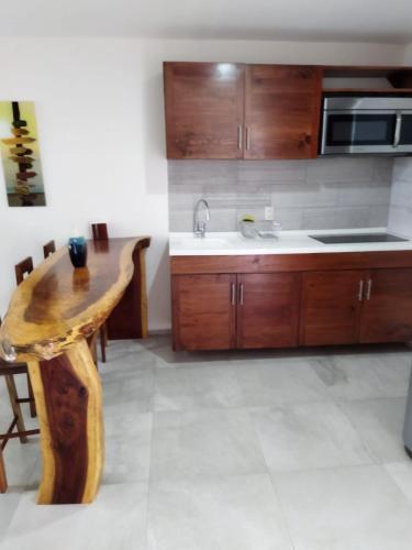 a kitchen with wooden cabinets and a wooden table at Playa & Piscina en Punta Gaviota in Tangolunda