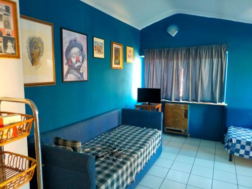 Habitación azul con cama y TV en Patty's Penthouse, en Cepagatti