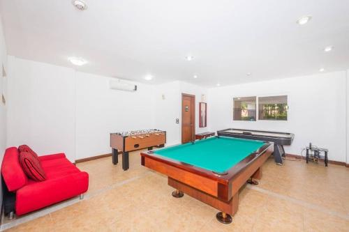 a living room with a pool table and a red couch at ✰Upscale 3Bdr condo✰ Incredible amenities ✰Fast wifi in Tamarindo