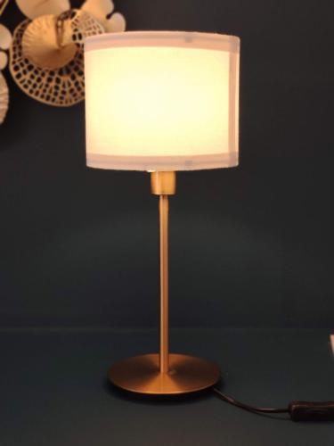 a lamp with a white shade on a table at Résidence Beaudelot in Saint-Saulve