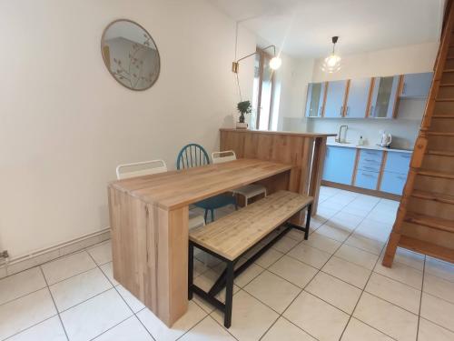 a kitchen with a wooden table and a wooden bench at Résidence Beaudelot in Saint-Saulve