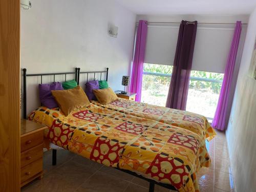 - une chambre avec un lit et une fenêtre avec des rideaux violets dans l'établissement JÚPITER EN EDIFICIO REMEDIOS, à Los Llanos de Aridane