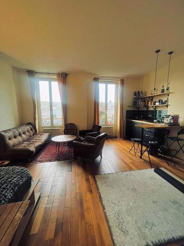 a living room with a couch and a table at Villa Ermitage-Appartement Paris - Buttes Chaumont in Paris