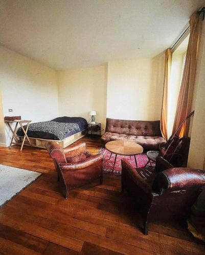 - un salon avec un canapé et un lit dans l'établissement Villa Ermitage-Appartement Paris - Buttes Chaumont, à Paris