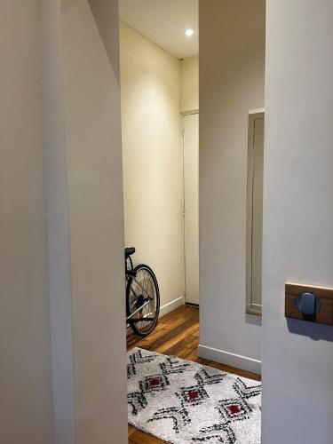 un vélo est assis dans le coin d'une pièce dans l'établissement Villa Ermitage-Appartement Paris - Buttes Chaumont, à Paris