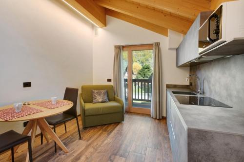 a kitchen and dining room with a table and a table and chairs at Olympic Chalet 12 in Bormio
