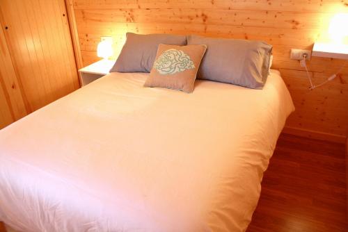 a white bed with two pillows on top of it at Apartadiño in Pobra do Caramiñal