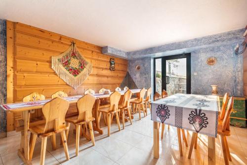 una sala da pranzo con pareti in legno, tavolo e sedie di Pokoje u Danusi a Groń