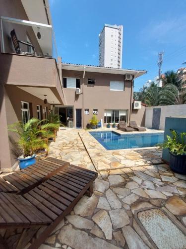 a house with a swimming pool next to a building at Hotel Casarão Pitangueiras in Guarujá