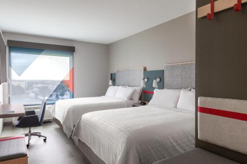 a hotel room with two beds and a window at avid Hotel - Toronto - Vaughan Southwest, an IHG Hotel in Vaughan
