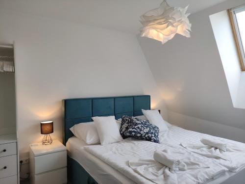 a bed with white sheets and pillows in a bedroom at Sunshine Residence Deluxe Apartment in Hévíz