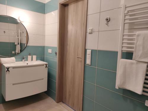 a bathroom with a sink and a mirror at Sunshine Residence Deluxe Apartment in Hévíz