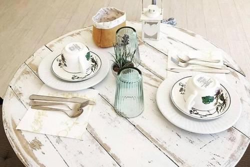 un tavolo bianco con piatti e utensili di Hotel Gli Acquerelli a Portoferraio