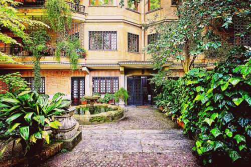 Un bâtiment avec une cour et une fontaine en face de celle-ci dans l'établissement Vatican House Apartment, à Rome