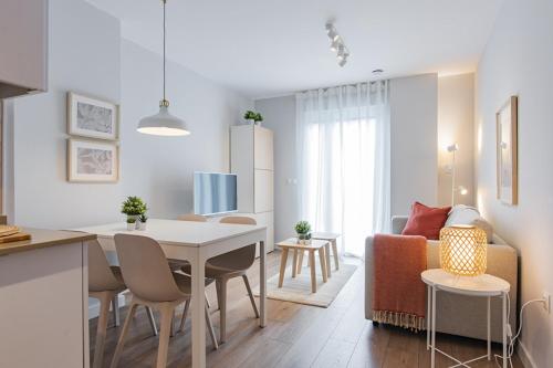 a kitchen and living room with a table and a couch at El Prau de Mito in Cangas de Onís