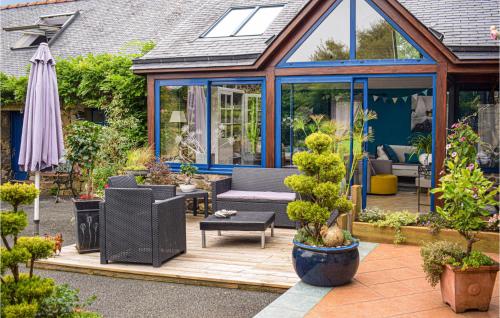 a garden with a conservatory with a table and chairs at Awesome Home In Trézélanbégard in Trézelan