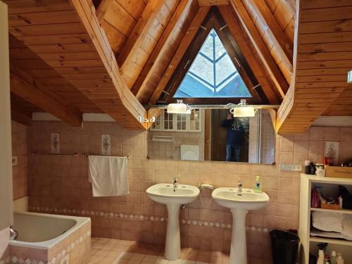 a bathroom with two sinks and a tub and a window at Skichaletcervinia Ski in Ski out 8p op piste nr. 5 uitzicht Matterhorn in Breuil-Cervinia