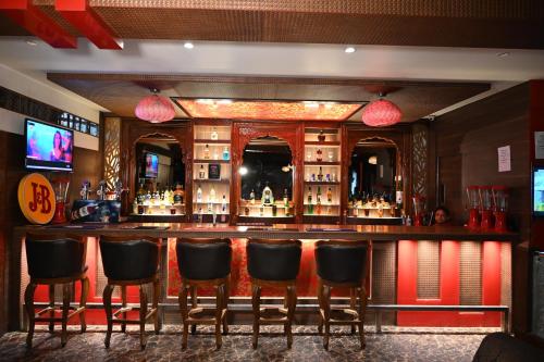 a bar with leather chairs in a room at Hotel Lawrence in Amritsar