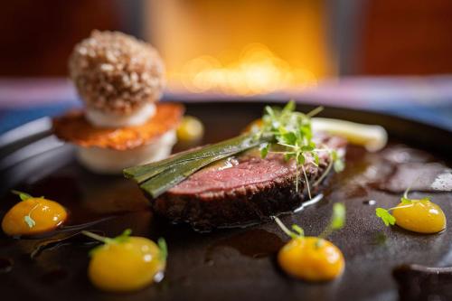 a plate of food with a piece of meat and vegetables at No11 Boutique Hotel & Brasserie in Edinburgh