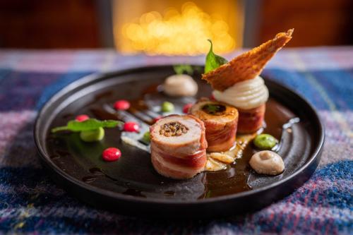 a black plate with food on a table at No11 Boutique Hotel & Brasserie in Edinburgh