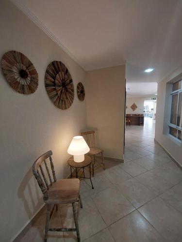 a living room with chairs and a table and a lamp at Hotel Casarão Pitangueiras in Guarujá
