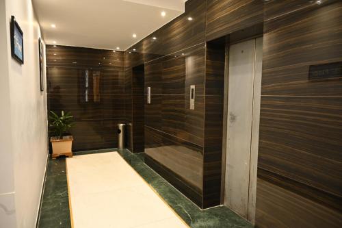 a bathroom with a shower with wooden walls at Hotel Lawrence in Amritsar