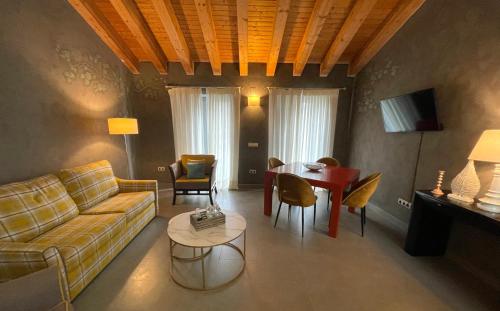 a living room with a couch and a table at Ritual Sevilla Suites - Malaver 23 in Seville